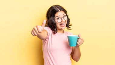 Genç İspanyol kadın gururlu, olumlu bir şekilde gülümsüyor. kahve fincanı konsepti