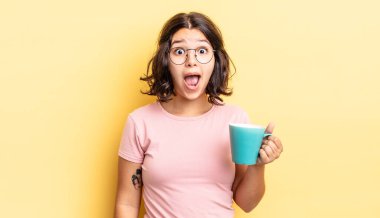 Genç İspanyol kadın çok şaşırmış ya da şok olmuş görünüyor. kahve fincanı konsepti