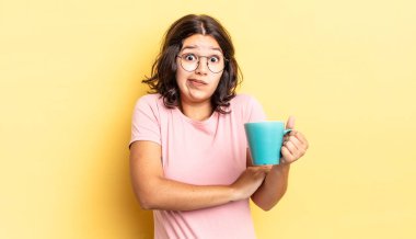 Genç İspanyol kadın omuz silkiyor, kafası karışık ve kararsız. kahve fincanı konsepti