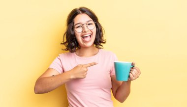 Genç İspanyol kadın heyecanlı ve şaşırmış görünüyor. kahve fincanı konsepti