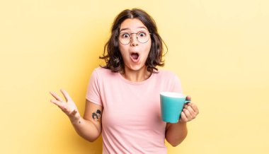 Genç İspanyol kadın inanılmaz bir sürprizle şaşkına dönmüş ve hayrete düşmüştü. kahve fincanı konsepti