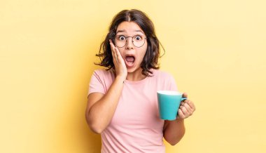 Genç İspanyol kadın şok olmuş ve korkmuş hissediyor. kahve fincanı konsepti