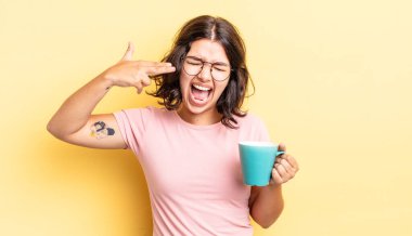 Genç İspanyol kadın mutsuz ve stresli görünüyor, intihar jesti silah işareti yapıyor. kahve fincanı konsepti