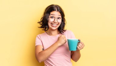 Genç İspanyol kadın kendini mutlu hissediyor ve bir meydan okumayla yüzleşiyor ya da kutluyor. kahve fincanı konsepti