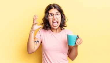 Genç İspanyol kadın ellerini havaya kaldırarak çığlık atıyor. kahve fincanı konsepti