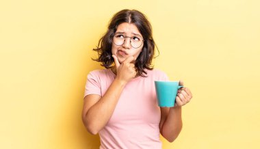 Genç İspanyol kadın düşünüyor, kuşkulu ve şaşkın hissediyor. kahve fincanı konsepti