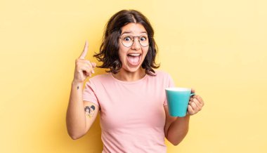 Genç İspanyol kadın bir fikri fark ettikten sonra mutlu ve heyecanlı bir dahi gibi hissediyor. kahve fincanı konsepti