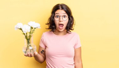 Genç İspanyol kadın çok şaşırmış ya da şok olmuş görünüyor. çiçek saksı konsepti