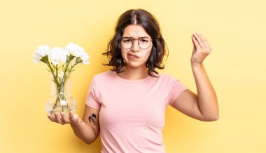 Genç İspanyol kadın kapiş ya da para hareketi yapıyor, sana ödemeni söylüyor. çiçek saksı konsepti