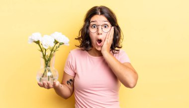 Genç İspanyol kadın şok olmuş ve korkmuş hissediyor. çiçek saksı konsepti