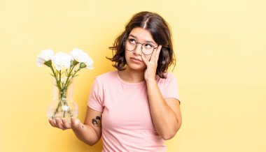 Genç İspanyol bir kadın bıkkın, hayal kırıklığına uğramış ve yorucu bir günün ardından uykulu hissediyor. çiçek saksı konsepti