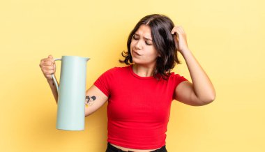 Genç İspanyol kadın mutlu bir şekilde gülümsüyor ve hayal kuruyor ya da şüphe ediyor. termos kavramı