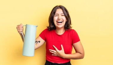 Genç İspanyol kadın komik bir şakaya yüksek sesle gülüyor. termos kavramı