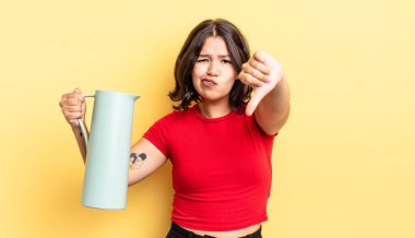 Latin kökenli genç bir kadın kızmış, baş parmağını kaldırmış. termos kavramı