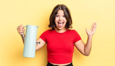 Genç İspanyol kadın kendini mutlu hissediyor ve inanılmaz bir şeye hayret ediyor. termos kavramı