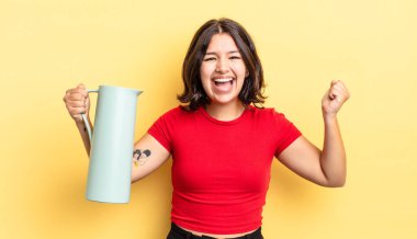 Genç İspanyol kadın şokta, gülüyor ve başarıyı kutluyor. termos kavramı