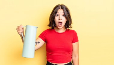 Genç İspanyol kadın çok şaşırmış ya da şok olmuş görünüyor. termos kavramı