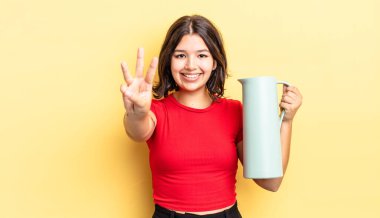 Genç İspanyol kadın gülümsüyor ve arkadaş canlısı görünüyor, üç numarayı gösteriyor. termos kavramı