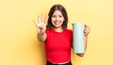 Genç İspanyol kadın gülümsüyor ve arkadaş canlısı görünüyor, dört numarayı gösteriyor. termos kavramı