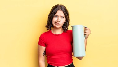 Genç İspanyol kadın üzgün, üzgün ya da kızgın hissediyor ve yana bakıyor. termos kavramı