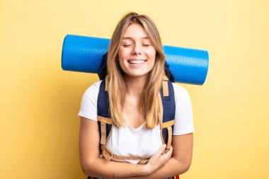 Güzel sarışın kız komik bir şakaya yüksek sesle gülüyor. Yürüyüş konsepti