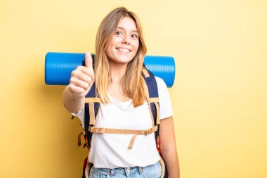 Güzel sarışın kız gururlu, olumlu gülümsüyor. Yürüyüş konsepti