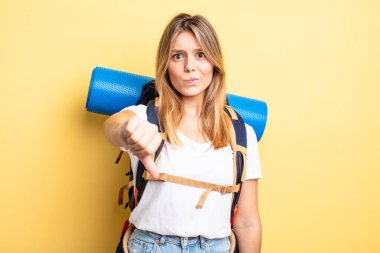 Güzel sarışın kız kendini kötü hissediyor, baş parmağını kaldırıyor. Yürüyüş konsepti