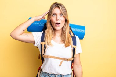 Güzel sarışın kız mutlu, şaşkın ve şaşırmış görünüyor. Yürüyüş konsepti