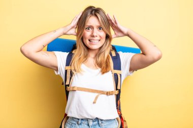 Güzel sarışın kız stresli, endişeli ya da korkmuş, elleri başının üstünde. Yürüyüş konsepti