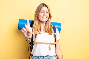 Güzel sarışın kız gururla gülümsüyor ve kendinden emin bir numara oluyor. Yürüyüş konsepti