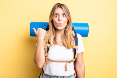 Güzel sarışın kız inançsızlıktan şaşkın şaşkın bakıyor. Yürüyüş konsepti