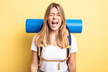 Güzel sarışın kız agresif bir şekilde bağırıyor, çok kızgın görünüyor. Yürüyüş konsepti