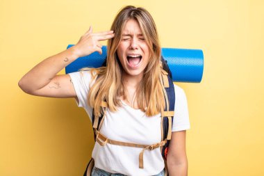 Güzel sarışın kız mutsuz ve stresli görünüyor, intihar jesti silah işareti yapıyor. Yürüyüş konsepti