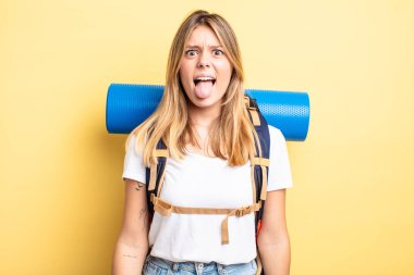 Güzel sarışın kız iğreniyor, sinirleniyor ve dilini çıkarıyor. Yürüyüş konsepti