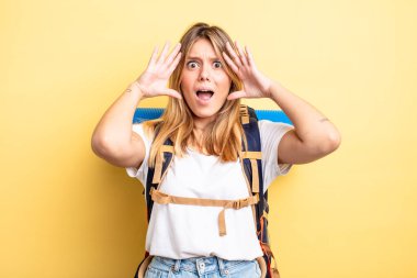 Güzel sarışın kız ellerini havaya kaldırarak çığlık atıyor. Yürüyüş konsepti