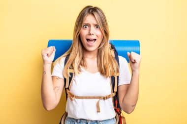 Güzel sarışın kız sinirli bir ifadeyle agresif bir şekilde bağırıyor. Yürüyüş konsepti