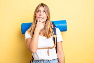 Güzel sarışın kız düşünüyor, kuşkulu ve şaşkın hissediyor. Yürüyüş konsepti