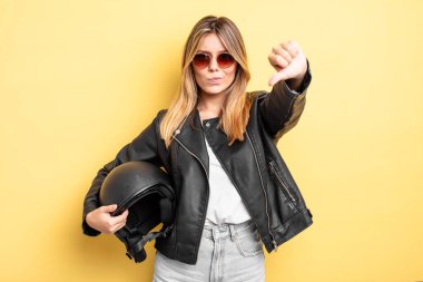 Güzel sarışın kız kendini kötü hissediyor, baş parmağını kaldırıyor. Motosiklet kaskı konsepti