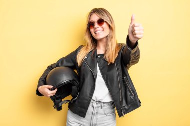 Güzel sarışın kız gururlu, olumlu gülümsüyor. Motosiklet kaskı konsepti