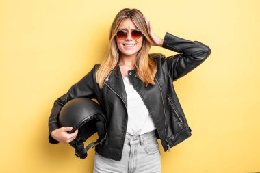 Güzel sarışın kız stresli, endişeli ya da korkmuş, elleri başının üstünde. Motosiklet kaskı konsepti