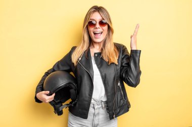 Güzel sarışın kız kendini mutlu hissediyor ve inanılmaz bir şeye hayret ediyor. Motosiklet kaskı konsepti