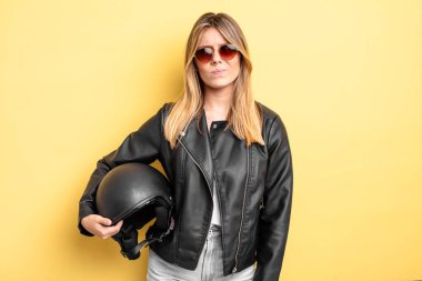 Güzel sarışın kız üzgün, üzgün ya da kızgın ve yana bakıyor. Motosiklet kaskı konsepti