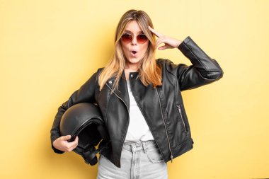 Güzel sarışın kız şaşırmış görünüyor, yeni bir düşünce, fikir ya da konsept fark ediyor. Motosiklet kaskı konsepti