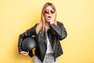 Güzel sarışın kız şok olmuş ve korkmuş hissediyor. Motosiklet kaskı konsepti