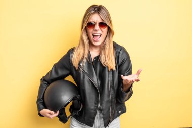 Güzel sarışın kız sinirli, sinirli ve sinirli görünüyor. Motosiklet kaskı konsepti