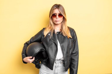 Güzel sarışın kız üzgün ve mızmızlanıyor. Mutsuz bir bakışı var ve ağlıyor. Motosiklet kaskı konsepti