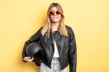 Güzel sarışın kız şaşkın ve şaşkın görünüyor. Motosiklet kaskı konsepti