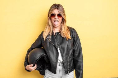 Güzel sarışın kız iğreniyor, sinirleniyor ve dilini çıkarıyor. Motosiklet kaskı konsepti