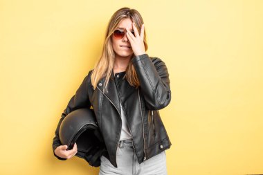 Güzel sarışın kız bıkkın, yorgun ve uykulu hissediyor. Motosiklet kaskı konsepti