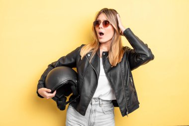 Güzel sarışın kız mutlu, heyecanlı ve şaşırmış hissediyor. Motosiklet kaskı konsepti